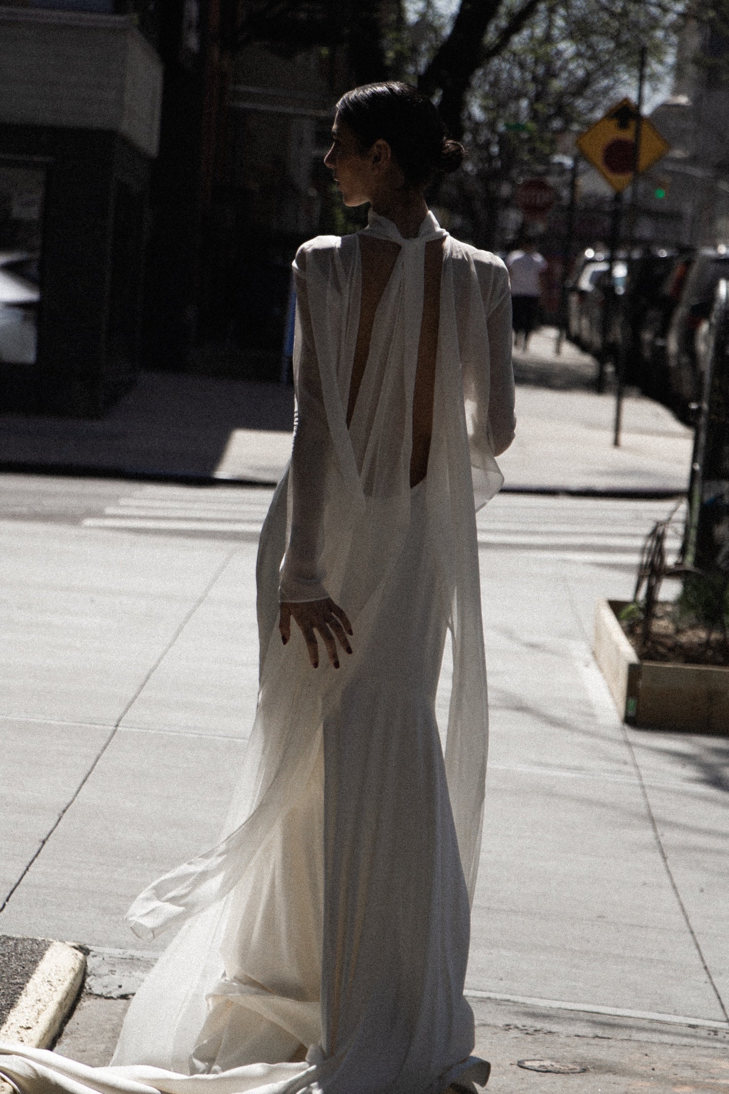 Woman in a white non traditional vintage-inspired silk slip wedding dress standing on a los angeles city street.