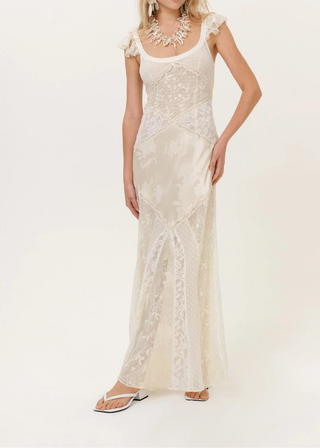 Woman wearing a white lace dress on a plain background