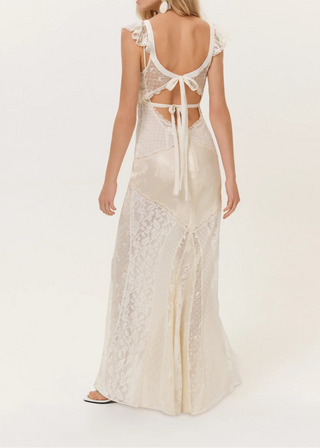 Woman wearing a white lace dress with a backless design on a white background