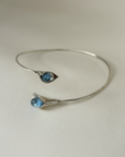 Silver bracelet with blue gemstones on a light gray background